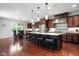 Well-lit kitchen featuring a large island with seating, stainless steel appliances, and hardwood floors at 13225 Gatman Ct, Carmel, IN 46032