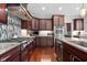 Kitchen with stainless steel appliances, granite countertops, and dark wood cabinets at 13225 Gatman Ct, Carmel, IN 46032