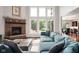 Bright living room with a brick fireplace, tall windows, and a comfortable couch perfect for Gathering gatherings at 13225 Gatman Ct, Carmel, IN 46032