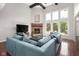Cozy living room featuring a brick fireplace, large windows, and a spacious couch, creating an inviting space for relaxation at 13225 Gatman Ct, Carmel, IN 46032