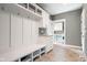 Bright mudroom with built-in storage, bench, and view of laundry room at 13225 Gatman Ct, Carmel, IN 46032