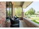 Relaxing outdoor seating on a brick-covered porch, offering a tranquil view of the landscaped garden and surrounding greenery at 13225 Gatman Ct, Carmel, IN 46032