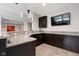 Beautiful wet bar with granite countertops, dark cabinetry, and a view of the theater room beyond at 13225 Gatman Ct, Carmel, IN 46032
