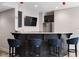 Basement wet bar with granite counters, stainless steel fridge, and plush seating, perfect for entertaining at 13225 Gatman Ct, Carmel, IN 46032