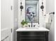 Stylish powder room with black vanity, elegant light fixtures, and modern skull artwork at 1326 E 10Th St, Indianapolis, IN 46202