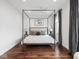 Serene bedroom with a four-poster bed, hardwood floors, and natural light at 1326 E 10Th St, Indianapolis, IN 46202