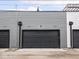 View of the rear of townhouses showing garages, modern gray siding, and alley access at 1326 E 10Th St, Indianapolis, IN 46202