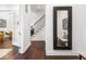 Bright hallway with dark hardwood floors, staircase and an elegant mirror at 1326 E 10Th St, Indianapolis, IN 46202