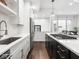 Modern kitchen with white cabinetry, stainless steel appliances, and a black island with barstool seating at 1326 E 10Th St, Indianapolis, IN 46202