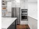Stainless steel appliances, white cabinets, and floating shelves in a modern kitchen at 1326 E 10Th St, Indianapolis, IN 46202