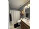 Gray bathroom featuring a shower with curtain, oak cabinet storage, and single sink vanity at 13660 N Ayrshire Cir, Camby, IN 46113