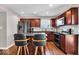 Kitchen with stainless steel appliances, island with seating, wooden cabinets and flooring at 159 Longleaf Ln, Greenfield, IN 46140