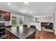 Open concept kitchen with stainless steel appliances, island with seating, and an open transition to the living room at 159 Longleaf Ln, Greenfield, IN 46140