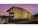 Exterior view of wood paneled building with a concrete path surrounded by a lawn and a sunset backdrop at 17354 Ditch Rd, Westfield, IN 46074