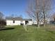 View of the backyard featuring a modest house with a well-maintained lawn at 1804 W 15Th St, Muncie, IN 47302