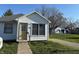 Charming home exterior featuring white siding, an inviting front door, and well-kept lawn at 1804 W 15Th St, Muncie, IN 47302