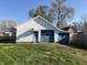 Detached garage featuring blue doors and white siding on a grassy lawn at 1804 W 15Th St, Muncie, IN 47302