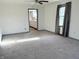 Large living room with new carpet, neutral walls, ceiling fan and large windows, creating an inviting atmosphere at 1804 W 15Th St, Muncie, IN 47302
