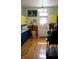 Well-lit kitchen with yellow upper cabinets, blue lower cabinets, wood floors, and a white door to the outside at 2025 Barth Ave, Indianapolis, IN 46203
