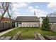 Backyard featuring a detached garage, green lawn, and mature trees, creating a private outdoor oasis at 2134 N New Jersey St, Indianapolis, IN 46202