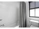 Clean bathroom with white subway tiles, a bathtub, and a window with modern blinds at 2134 N New Jersey St, Indianapolis, IN 46202