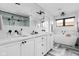 Bright bathroom boasting a double vanity with a large mirror and a soaking tub under a window at 2134 N New Jersey St, Indianapolis, IN 46202