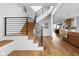Inviting entryway featuring hardwood floors, a modern staircase with black metal railing, and an open floor plan at 2134 N New Jersey St, Indianapolis, IN 46202