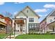 Charming two-story home with a covered porch, manicured lawn, and beautiful green and white color scheme at 2134 N New Jersey St, Indianapolis, IN 46202