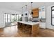 Modern kitchen featuring a large island with seating and pendant lighting, with sliding doors to an outdoor patio at 2134 N New Jersey St, Indianapolis, IN 46202