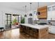 Open kitchen featuring a large island with seating, pendant lighting, and access to an outdoor patio at 2134 N New Jersey St, Indianapolis, IN 46202
