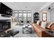 Bright living room featuring large windows, a modern fireplace, sleek furnishings, and hardwood floors at 2134 N New Jersey St, Indianapolis, IN 46202