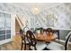 Elegant dining room featuring a chandelier, gray wallpaper, a dining table with seating for six, and stairs view at 2250 Egbert Rd, Westfield, IN 46074