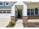 Inviting front porch with brick columns, a stylish front door with wreath, and a well-kept garden bed at 2250 Egbert Rd, Westfield, IN 46074