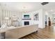 Bright living room featuring a neutral sofa, fireplace, striped wallpaper, wood flooring, and a view into the hallway at 2250 Egbert Rd, Westfield, IN 46074
