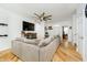 Bright living room with hardwood floors, large gray sofa, and stylish ceiling fan at 2263 N Delaware St, Indianapolis, IN 46205