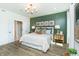 Charming bedroom with a decorative green accent wall, a comfortable bed, and an ensuite bathroom at 261 Onset Way, Westfield, IN 46074