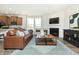 Cozy living room with a fireplace, leather sofa, and seamless access to the kitchen at 261 Onset Way, Westfield, IN 46074