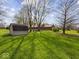 Spacious backyard features a large grassy area, mature trees, and a storage shed at 2810 Winterway Dr, Shelbyville, IN 46176