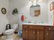 This bathroom features a wooden vanity with a white countertop and a toilet with a patterned wall at 2810 Winterway Dr, Shelbyville, IN 46176