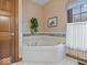 Bathroom with a tub, window, and decorative wallpaper at 2810 Winterway Dr, Shelbyville, IN 46176