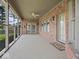 Relaxing covered patio with brick walls, ceiling fan, and screened portion, seamlessly blending indoor and outdoor living at 2810 Winterway Dr, Shelbyville, IN 46176