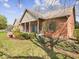Charming brick ranch home with a cozy front porch, green shutters, and mature landscaping at 2810 Winterway Dr, Shelbyville, IN 46176