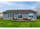 Rear view of the home showcasing the manicured lawn and outdoor patio space at 2890 Trillium Way, Columbus, IN 47201
