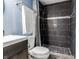 Charming bathroom with a dark vanity, round mirror, and tile shower at 2890 Trillium Way, Columbus, IN 47201