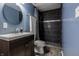 Modern bathroom featuring a dark vanity, round mirror, and tile shower at 2890 Trillium Way, Columbus, IN 47201