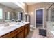 Bright bathroom featuring a double sink vanity, framed mirror, shower, and walk-in closet at 2890 Trillium Way, Columbus, IN 47201
