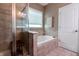Beautiful bathroom featuring a walk-in shower, soaking tub, and natural light from the window at 2890 Trillium Way, Columbus, IN 47201