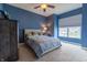 Blue bedroom featuring carpet flooring, a ceiling fan, and a queen-sized bed with blue patterned bedding at 2890 Trillium Way, Columbus, IN 47201