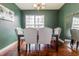 Dining room with emerald walls, natural lighting, and a black wooden table and chairs at 2890 Trillium Way, Columbus, IN 47201