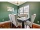 Green dining room with a dark table, decorative centerpiece, and gray upholstered chairs at 2890 Trillium Way, Columbus, IN 47201
